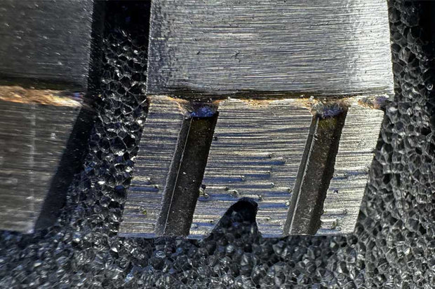 Close-up of a saw blade tooth with a textured surface