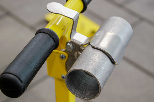 A close-up of a Vac Max Relief Valve attached to a yellow and black plumbing fixture, with a metallic finish on the valve and a rubber handle.